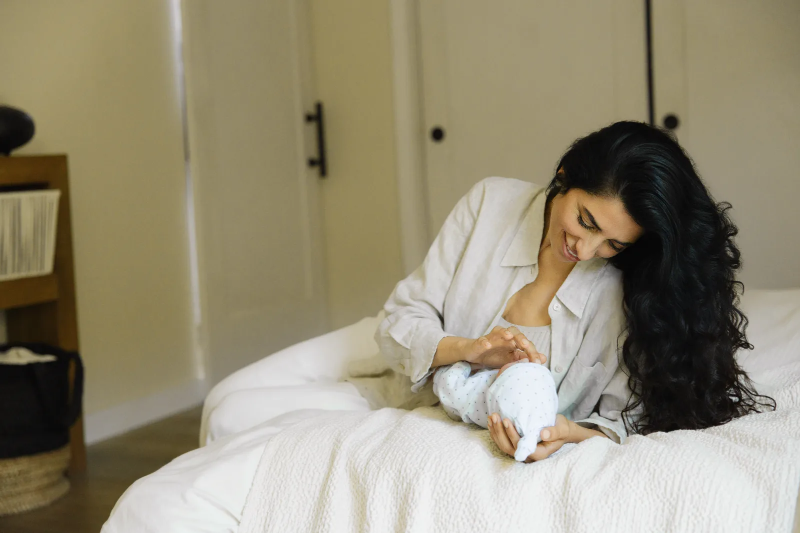 A mother resting on the bed with her newborn